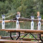 DIY Solar - four water bottles sitting on top of a picnic table