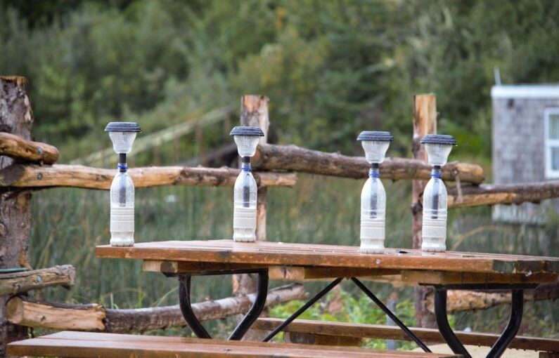 DIY Solar - four water bottles sitting on top of a picnic table