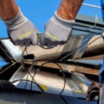 Religious Solar - two men carrying a metal sheet