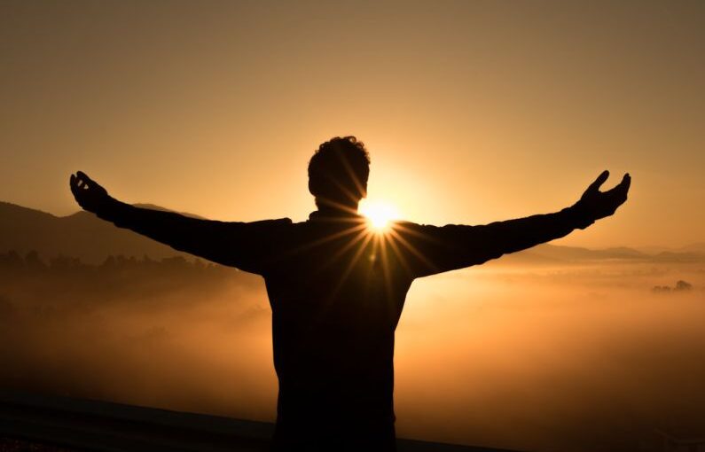 Success Solar - silhouette photo of man on cliff during sunset