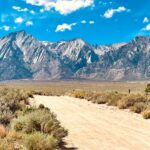 Independence Solar - a dirt road in front of a mountain range