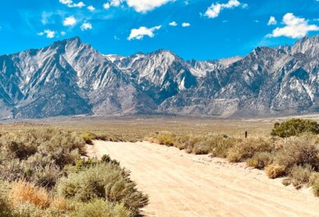 Independence Solar - a dirt road in front of a mountain range