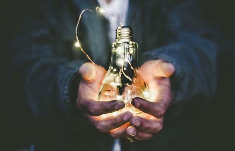 Solar Innovation - man holding incandescent bulb