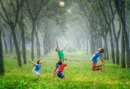 Jakarta Solar - four boy playing ball on green grass