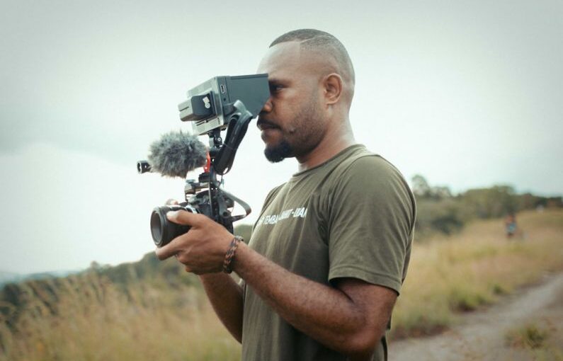 Papua Solar - a man holding a camera