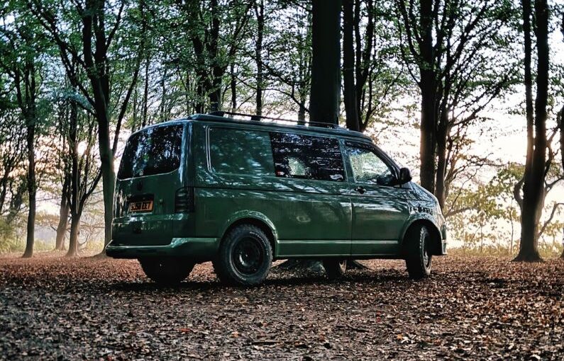 Off-grid Solar - a green van is parked in the woods