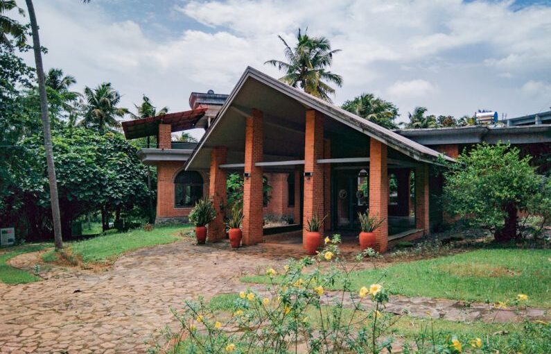 Tourism Solar - a brick house with potted plants in front of it