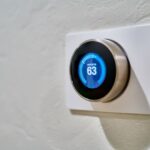 Smart Homes - gray Nest thermostat displaying at 63