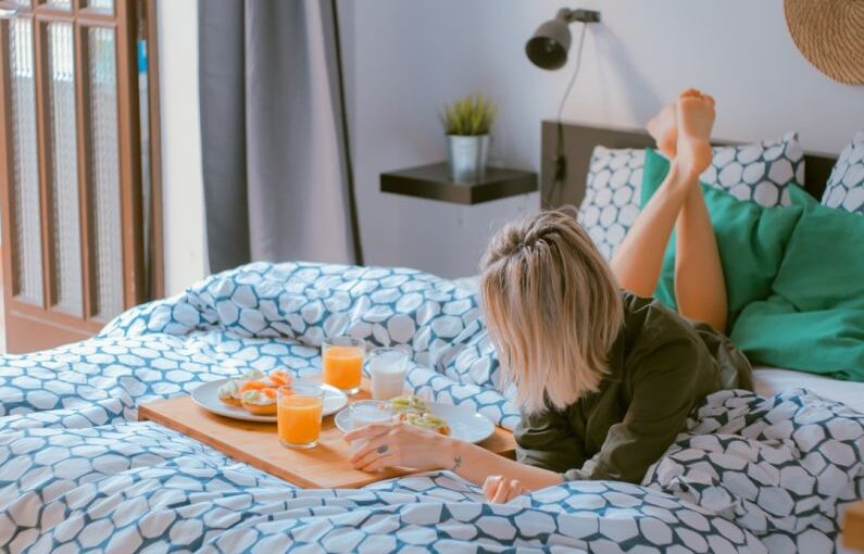 Home Tips - woman lying on bed white holding board